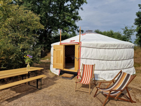 Una yurta mongola en la casa de la naturaleza Zomerlicht en los Países Bajos con sillas y mesa afuera.