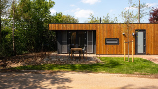 Front view of Happy Oak Lodge at Holiday Park Mölke, Netherlands, featuring modern wood panel design.