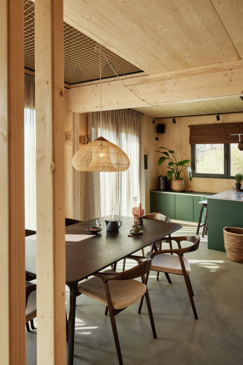 Comedor moderno con detalles de madera y lámpara colgante en Unbrick One | Sauna y Piscina en Brinckerduyn, Países Bajos.