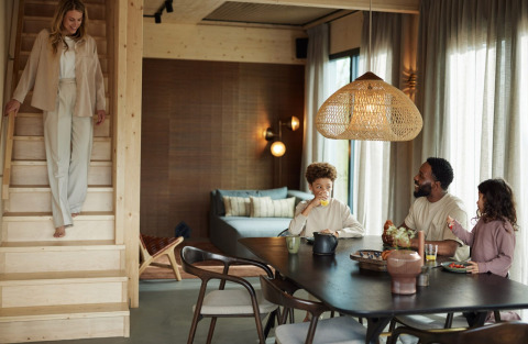 Familia desayunando junta en un moderno lodge de madera en Brinckerduyn, Países Bajos, con decoración cálida.