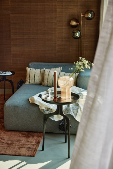 Salón moderno en Unbrick One, Brinckerduyn, con sofá gris, lámpara elegante y mesa auxiliar contemporánea.