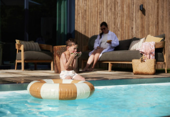 Niño comiendo sandía junto a la piscina en Unbrick One | Sauna and Pool en Brinckerduyn, Países Bajos.