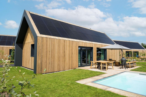 Lodge moderno Unbrick One en Brinckerduyn, Países Bajos, con fachada de madera, paneles solares, terraza y piscina.