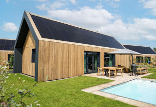 Lodge Unbrick One moderne à Brinckerduyn, Pays-Bas, avec façade bois, panneaux solaires, terrasse et piscine.