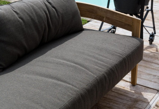 Buitenlounge zetel aan het zwembad bij Unbrick One | Sauna en Pool in Brinckerduyn, Nederland, op houten terras.