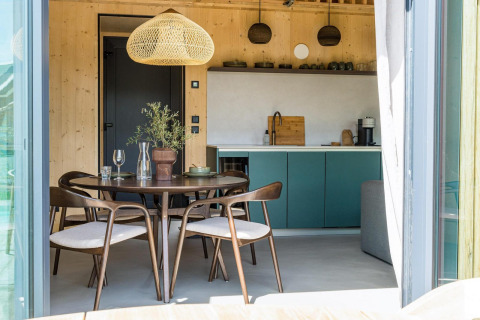 Acogedora cocina y comedor de cabaña moderna con detalles en madera y luz natural en Brinckerduyn, Países Bajos.