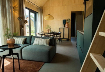 Zona giorno e pranzo moderna in Unbrick One Lodge con vista esterna, Brinckerduyn, Paesi Bassi.