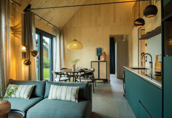 Vista interna di un lodge moderno presso Unbrick One | Sauna e Piscina, Brinckerduyn, Paesi Bassi, con cucina e soggiorno.
