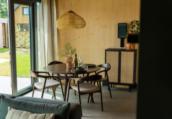 Zona pranzo moderna con mobili in legno in Unbrick One, Brinckerduyn, Paesi Bassi, vista giardino.