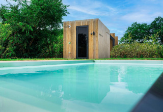 Modern lodge Unbrick One with sauna and pool at Brinckerduyn, Netherlands, set in lush green nature.