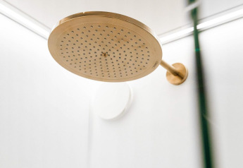 Regendouchekop in een moderne badkamer bij Unbrick One | Sauna en Zwembad in Brinckerduyn, Nederland.