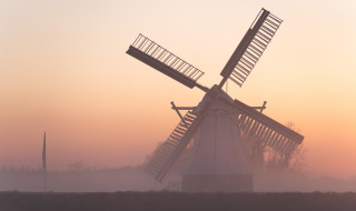 Molino de viento en un amanecer brumoso, Drenthe, Países Bajos