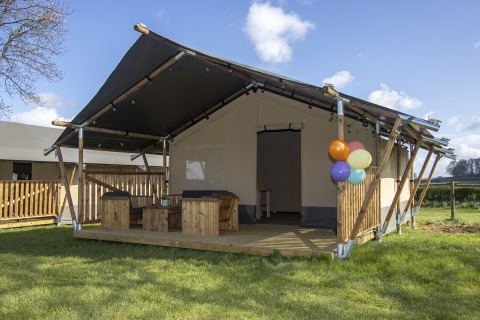 Luxury safari tent cabin with wooden veranda and balloons at Camping Catsop, Limburg, Netherlands.