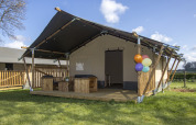 Tenda safari di lusso con veranda in legno e palloncini al Camping Catsop, Limburg, Paesi Bassi.
