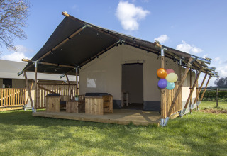 Luxury safari tent cabin with wooden veranda and balloons at Camping Catsop, Limburg, Netherlands.