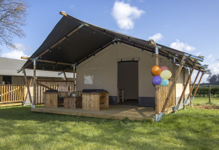 Cabaña de tienda safari de lujo con terraza de madera y globos en Camping Catsop, Limburg, Países Bajos.