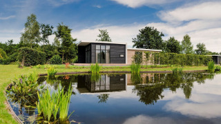 Kleines Haus am Teich im Vakantiepark Hölte, Niederlande, mit moderner Architektur und Natur.