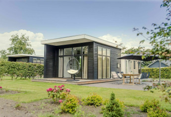 Moderna lodge con ampie vetrate e patio nel Vakantiepark Hölte, Paesi Bassi.