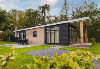 Luxe lodge met sauna bij Vakantiepark Hölte in Nederland, met ruime ramen en natuurlijke groene omgeving.