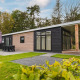 Moderne luksuslodge med sauna, store vinduer og terrasse ved Vakantiepark Hölte, omgivet af grøn natur.