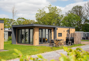 Moderne Oak Lodge met hottub op Vakantiepark Hölte in Nederland, gelegen tussen het groen.