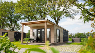 Panorama lodge with wellness and jacuzzi at Vakantiepark Hölte in the Netherlands, surrounded by greenery.