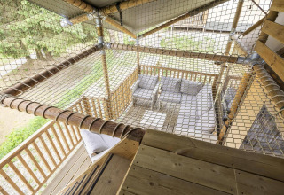 Zicht vanaf een houten terras in Ranger Lodge safaritent, met hangnet en loungegedeelte eronder.