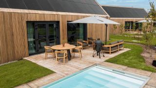 Lodge moderno Unbrick One con fachada de madera, terraza, piscina y muebles exteriores en De Weelderik, Países Bajos.