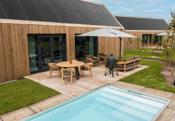 Moderno lodge Unbrick One con facciata in legno, terrazza, piscina e arredi da esterno a De Weelderik, Paesi Bassi.