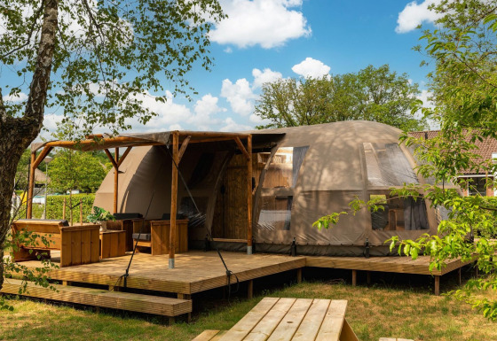 Riverdome lodge con terraza y zona de estar en Holiday Park Mölke, Países Bajos, rodeado de naturaleza.