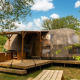 Riverdome-lodge med terrasse og siddepladser ved Holiday Park Mölke i Holland, omgivet af natur.