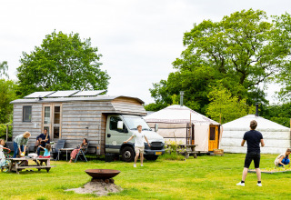 Vakantiegangers bij Zomerlicht, Overijssel, Nederland, genieten voor tiny house en yurts op groen grasveld.
