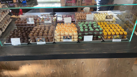 Assortiment ambachtelijke pralines achter glas, uitgestald bij Camping de Waterbuffelfarm in Overijssel.