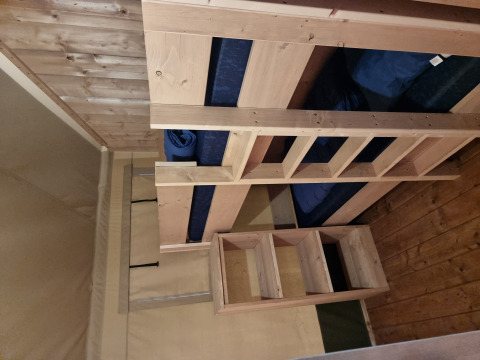 Interieur van een safaritent met houten stapelbed bij Camping Bockenauer Schweiz in Duitsland.