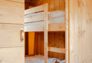 Gezellige slaapruimte in een safaritent met houten stapelbedden en houten wanden, Safari tent + sanitary.