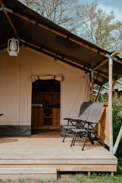 Tienda safari con porche y sillas en Camping de Haer, Países Bajos. Entrada cubierta a la tienda.