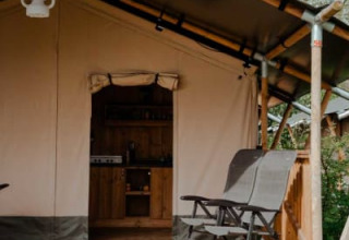 Tenda safari con veranda e sedie presso Camping de Haer, Paesi Bassi. Ingresso coperto alla tenda.