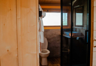 Binnenzicht van badkamer in safaritent met toilet en wastafel bij Camping de Haer, Nederland.