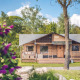 Safari-teltet 'Red Deer' på Holiday park Ackersate i Holland, omgivet af grønne træer og blomster.