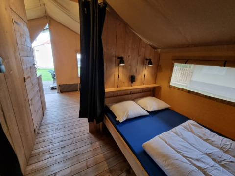 Safari-Zelt mit Holzboden und Doppelbett im Camping de Tulpenweide in den Niederlanden, Innenansicht