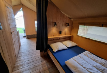 Safari-Zelt mit Holzboden und Doppelbett im Camping de Tulpenweide in den Niederlanden, Innenansicht