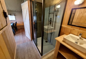 Badkamer in een safaritent met douche en lavabo bij Camping de Tulpenweide in Nederland.
