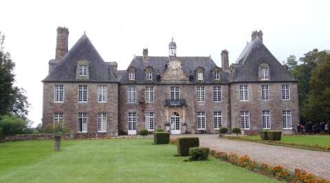 Tienda safari en Glamping des 2 Marguerites en Francia, con mansión histórica y jardín bien cuidado al frente.