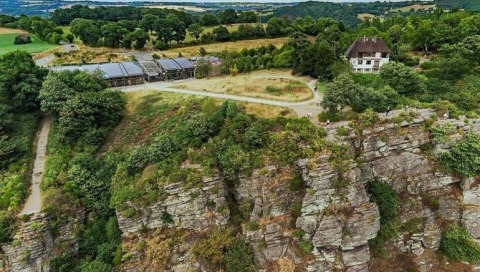 Luftfoto af Safari-telt ved Glamping des 2 Marguerites i Frankrig med klippe og grønne marker omgivelser.