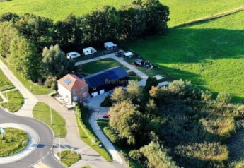 Vista aérea de la tienda Safari en Camping de Noorde, Países Bajos, rodeada de campos y una rotonda.
