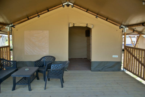 Safari-Zelt mit überdachter Terrasse und Kunststoffmöbeln bei Minicamping de Vrolijke Flierefluiter in den Niederlanden.