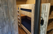 Interior of a safari tent with wooden bunk beds and floor at Camping het Horstmannsbos in the Netherlands.