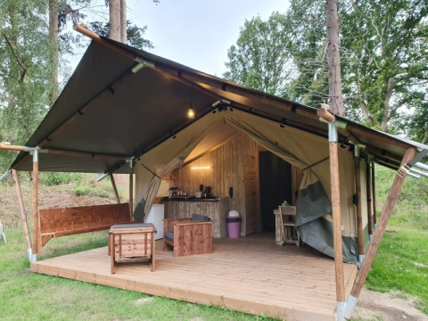 Tenda safari con terrazza e servizi igienici privati al Camping het Horstmannsbos nei Paesi Bassi, tra gli alberi.