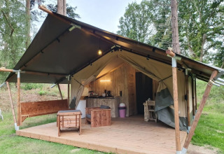 Safari-Zelt mit Terrasse und sanitären Anlagen bei Camping het Horstmannsbos in den Niederlanden im Wald.