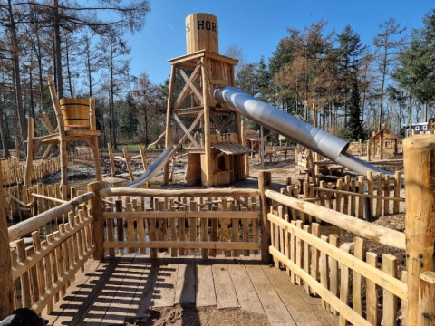 Parque infantil con tobogán y vallas de madera en Camping het Horstmannsbos en los Países Bajos.